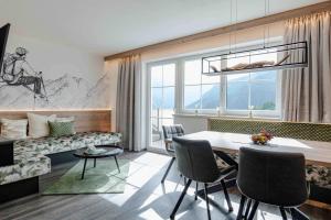 a living room with a table and chairs and a couch at Apart-Pension Bergland in Ladis