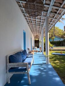 a porch with a couch and chairs under a ceiling at Pousada Caraíva in Caraíva