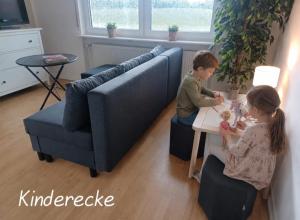 a boy and a girl playing with dolls in a living room at Ebenerdiges Ferienhaus für Rückzug und Auszeit mit Sauna, Weitblick, Terrassen, Privatsphäre auf 20000 qm NaturZentral in Frankenberg