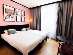 a hotel room with two beds and a window at ibis Styles Dijon Central in Dijon +109 photos