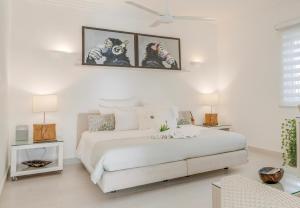a white bedroom with a large white bed in a room at Casa Veintiuno in Sosúa +108 photos