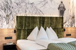 a bedroom with a bed with a drawing on the wall at Apart-Pension Bergland in Ladis