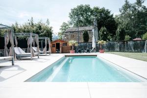 a swimming pool with chairs and a house at Chateau de La Lanette in Saléchan