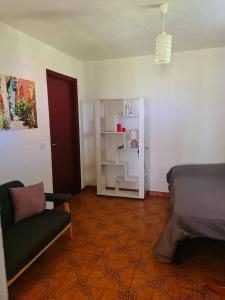 a room with a bed and a chair and a refrigerator at Casa vacanze a Roccella Jonica in Roccella Ionica