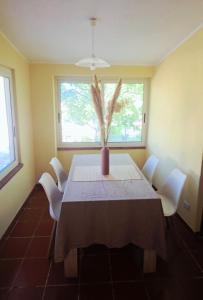 a dining room table with a vase with a plant at Casa vacanze a Roccella Jonica in Roccella Ionica +5 photos