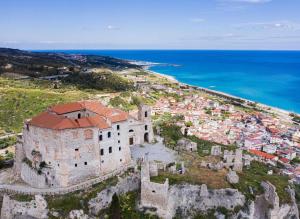an old building on a hill next to the ocean at Casa vacanze a Roccella Jonica in Roccella Ionica