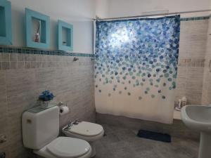 a bathroom with a toilet and a shower at Casa AONIKENK in Villa Dolores