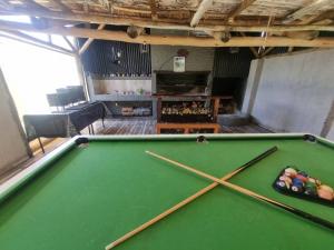 a pool table in a room with two cue sticks at Casa AONIKENK in Villa Dolores