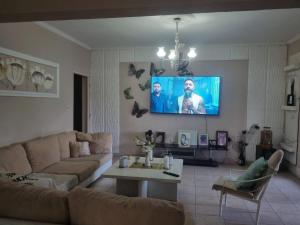 a living room with a couch and a tv on the wall at Casa AONIKENK in Villa Dolores +5 photos