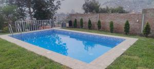 a blue swimming pool in a yard next to a fence at villa vilcar in Cali