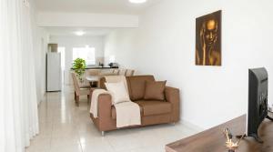 a living room with a couch and a television at Apartamento na Sapetinga - Melhor Pôr do Sol da cidade e com 3 Quartos in Ilhéus