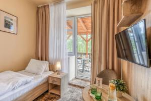 a bedroom with a bed and a table and a window at Hotel Slunce - wellness s bazénem, pivovar Morous a bowling in Rýmařov +48 photos