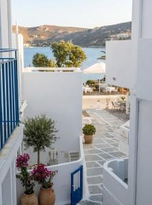 a white balcony with potted plants and a view of the ocean at Harmony Serifos in Livadi
