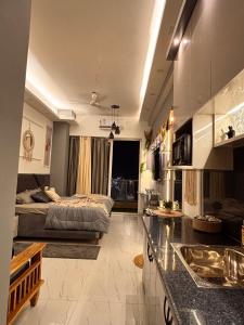 a living room with a bed and a kitchen with a counter at The cozy corner in Ghaziabad