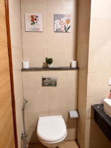 a small bathroom with a toilet and a sink at The cozy corner in Ghaziabad +12 photos
