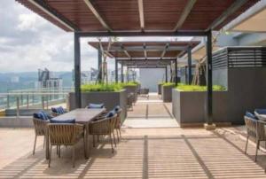 a patio with tables and chairs on a balcony at Blue aura in Kuala Lumpur