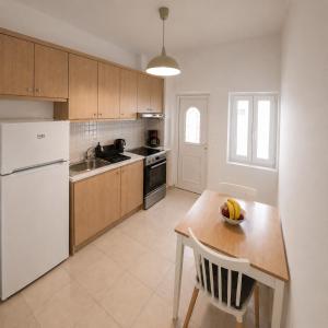 a kitchen with a white refrigerator and a wooden table at Harmony Serifos in Livadi