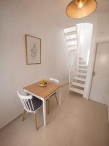 a dining room with a table and a staircase at Harmony Serifos in Livadi