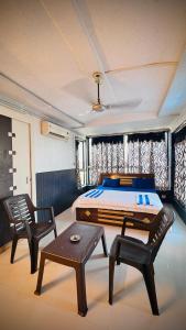 a bedroom with a bed and a table and chairs at Rooftopwaves penthouse in Daman