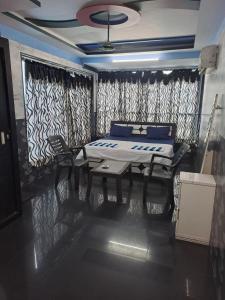a bedroom with a bed and a table and a window at Rooftopwaves penthouse in Daman