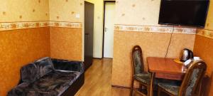 a room with a desk and a television on a wall at Zajazd-Restauracja ELZA in Kutno