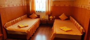 two beds in a room with yellow towels on them at Zajazd-Restauracja ELZA in Kutno