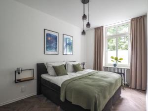 a bedroom with a large bed with green sheets at Idylle Apartments - Suite Kaisergrün in Bad Ems