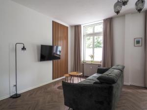 a living room with a couch and a tv at Idylle Apartments - Suite Kaisergrün in Bad Ems