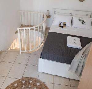 a bedroom with a white bed and a chair at Harmony Serifos in Livadi