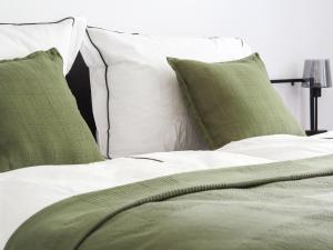a bed with green and white sheets and pillows at Idylle Apartments - Suite Kaisergrün in Bad Ems +25 photos