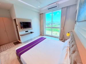 a bedroom with a large bed with a large window at Hotel Purple Lotus Suites in Chauk