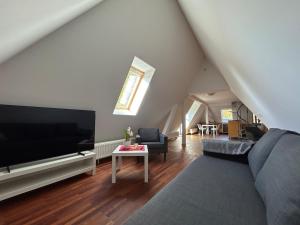 a living room with a large television and a couch at Charming Apartment Stade in Stade