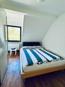 a bedroom with a bed with blue and white stripes at Charming Apartment Stade in Stade