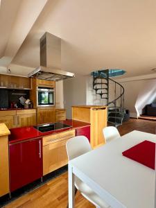a kitchen with red cabinets and a white table with chairs at Charming Apartment Stade in Stade