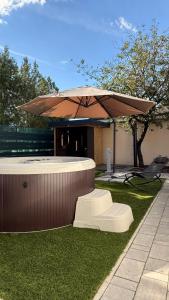 a large umbrella sitting on the grass in a yard at CasaBruno Vendégház Celldömölk in Celldömölk