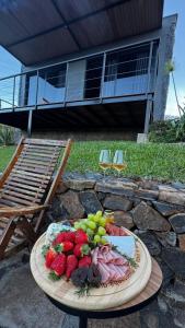 a plate of fruit on a table in front of a house at Cabana Chácara Vilagio daspedras in Nova Petrópolis +25 photos