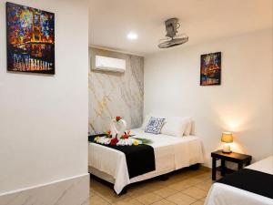 a bedroom with a bed and a painting on the wall at Carey Lodging in Tortuguero