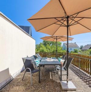 a table and chairs with an umbrella on a patio at Ferienhaus Primavera in Mörsdorf