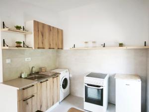 a kitchen with a sink and a washing machine at Apartmani Vukovic in Budva
