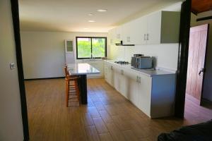 a kitchen with white cabinets and a table with a microwave at Lake Rapel, beautiful lake view in Las Cabras +23 photos