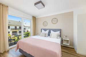 a bedroom with a large bed and a balcony at Ferienhaus Primavera in Mörsdorf