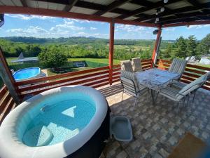 a hot tub on a patio with a table and chairs at Avala Sunset Apartments in Belgrade