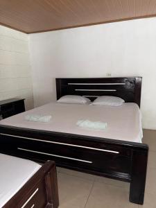 a large bed with two white pillows on it at Cabinas Chinchilla in Quepos