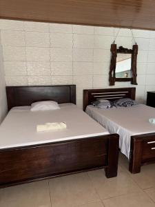 two beds sitting next to each other in a room at Cabinas Chinchilla in Quepos