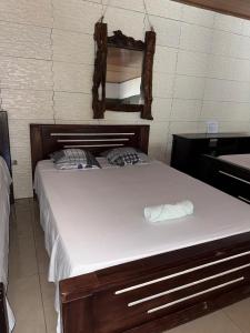 a large bed in a room with a mirror at Cabinas Chinchilla in Quepos +17 photos