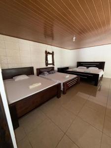 two beds are in a room with at Cabinas Chinchilla in Quepos