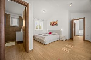 a white bedroom with a bed and a bathroom at Villa Karla, private pool, 3 bedroom in Divšići +22 photos