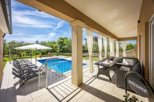 a patio with a table and chairs and a pool at Villa Karla, private pool, 3 bedroom in Divšići