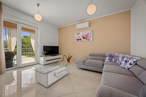 a living room with a couch and a tv at Villa Karla, private pool, 3 bedroom in Divšići