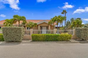 a house with a white fence and palm trees at Moko 159 in Noord